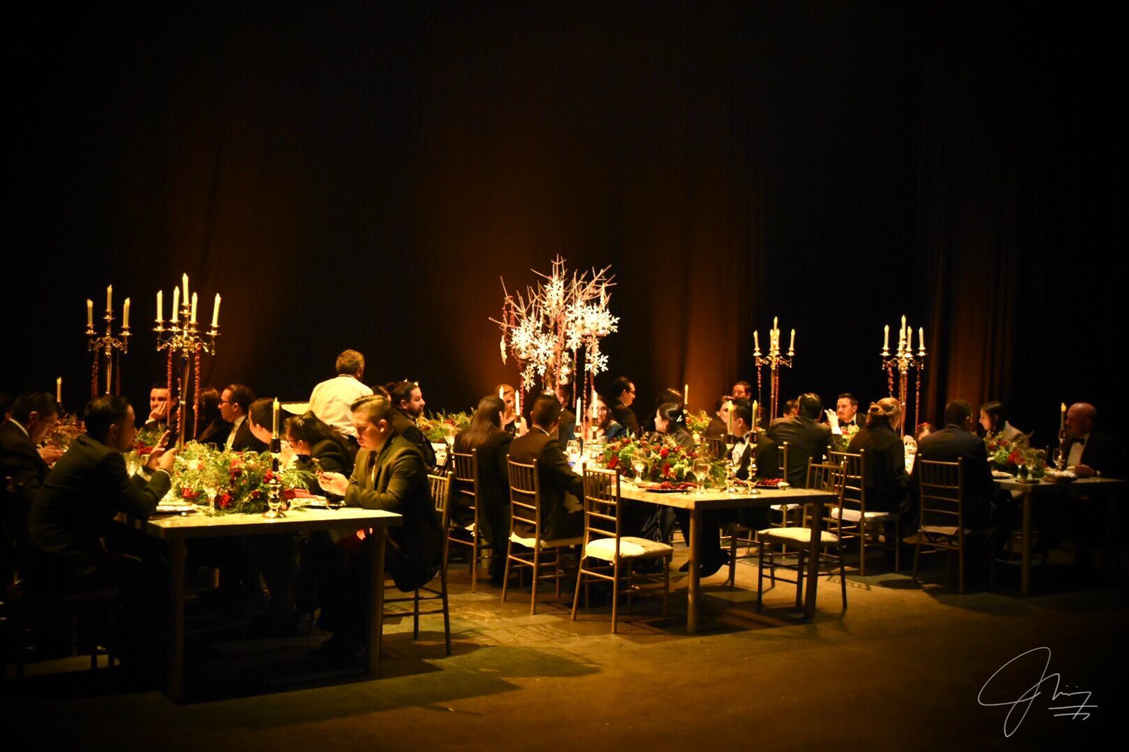 Cena de gala con candelabros sobre el escenario